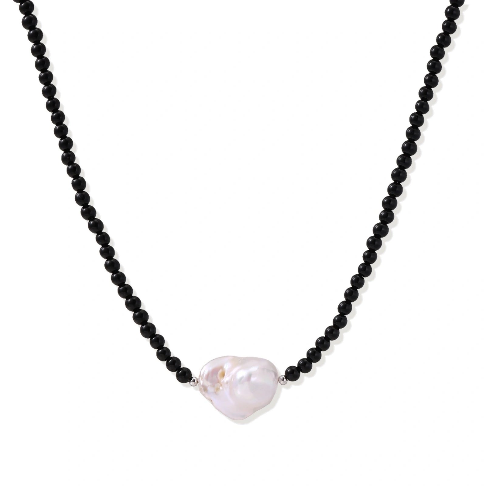 Beaded black agate necklace with iridescent baroque freshwater pearl centerpiece on cream background.