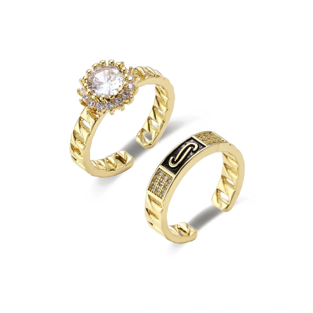 Gold-plated adjustable ring with twisted chain band, central cubic zirconia stone surrounded by crystal halo on cream background