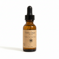 A 1oz amber glass dropper bottle of Timeless Organics Skin Care 'Timeless Hair Repair Serum' with a black dropper cap and a beige paper label, set against a warm beige background with soft diagonal shadows.