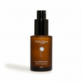 An amber glass pump bottle of Timless Organics Sun Tea Sun Defense Serum SPF 30 + Carrot Seed, set against a warm beige background with soft diagonal shadows.