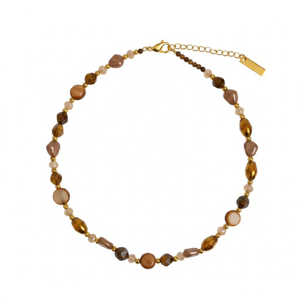 Beaded necklace on a wooden tray with a card underneath