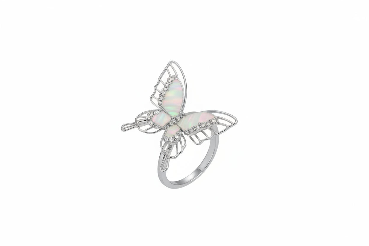 Butterfly-shaped ring on a person's finger with a neutral background