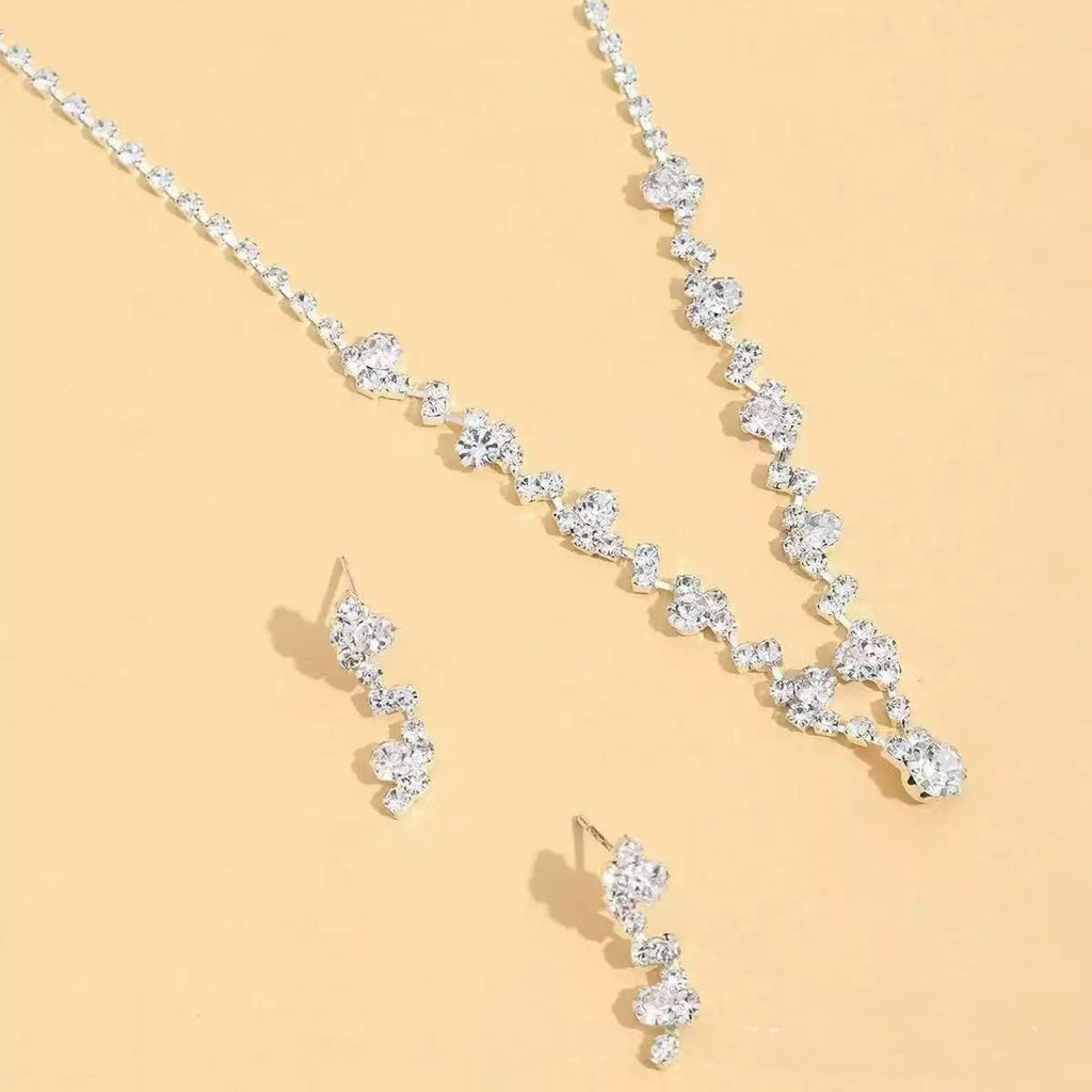 Diamond necklace and earrings on a beige background