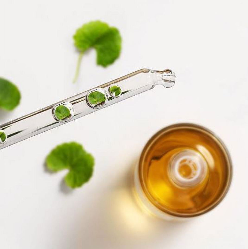 Glass dropper with green liquid next to a container of yellow liquid on a white background