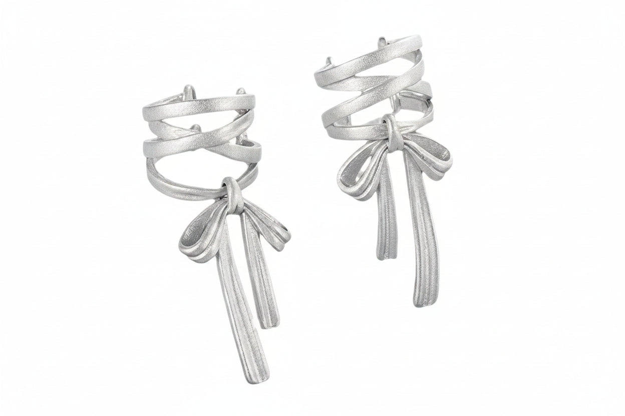Silver bow-shaped earrings on a white background