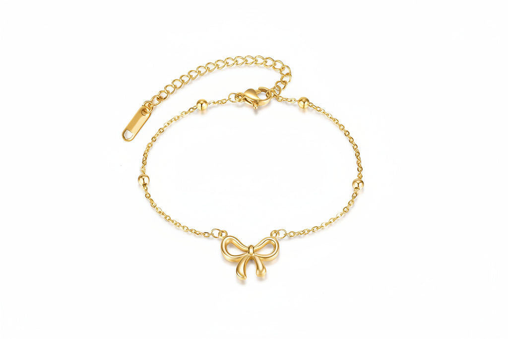 Gold bracelet with a bow charm and measurements on a white background