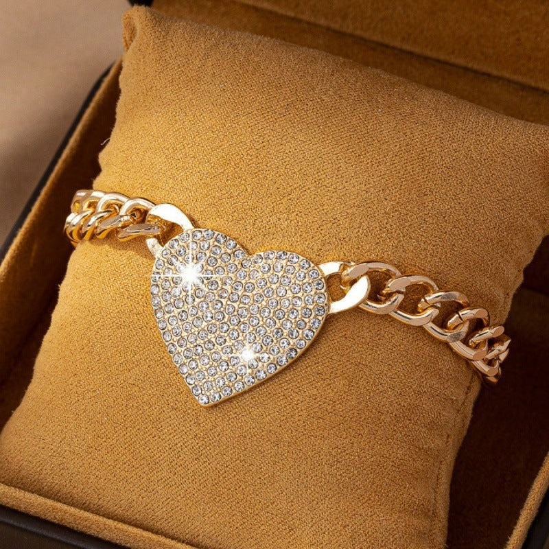 Gold bracelet with a heart-shaped diamond charm on a brown cushion