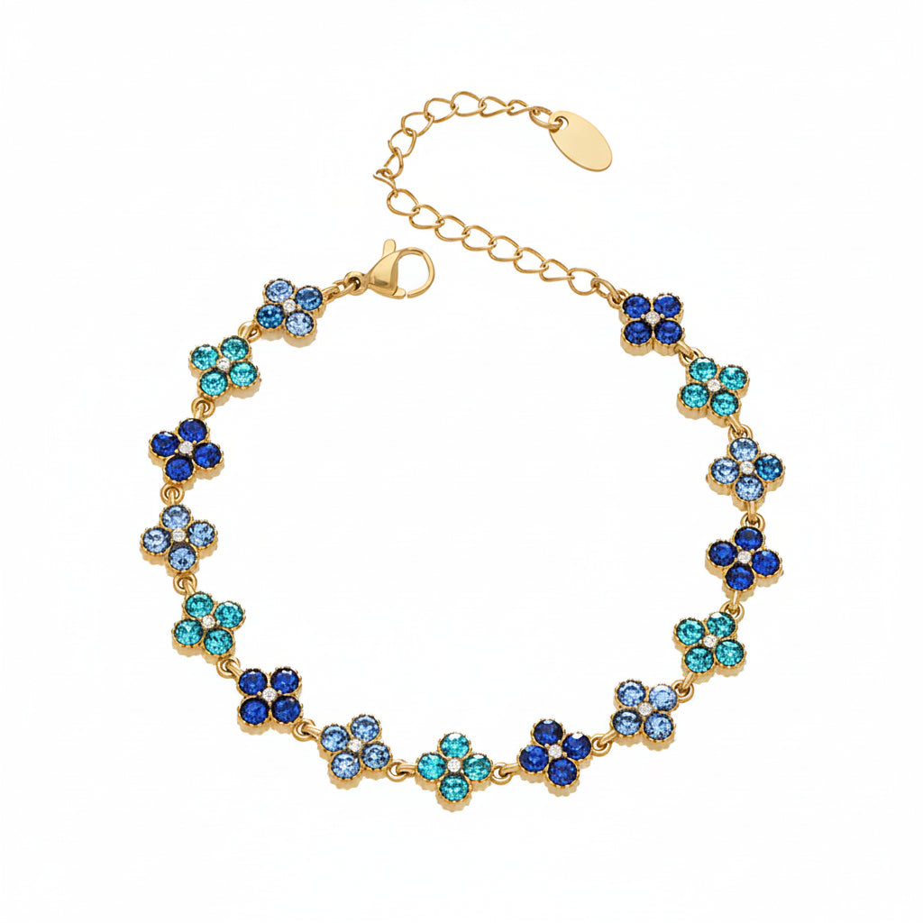 Gold bracelet with blue and green stones on a white background
