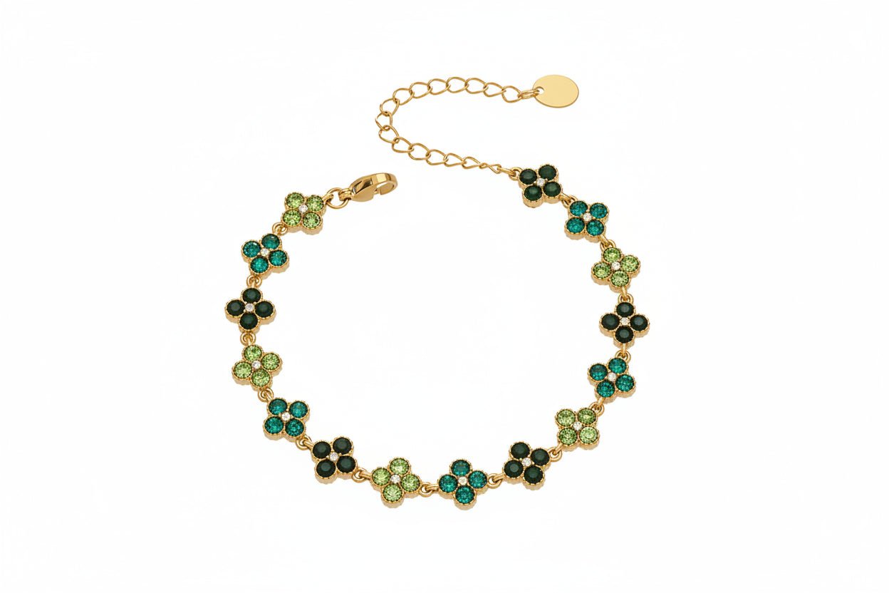Gold bracelet with green stones on a white background