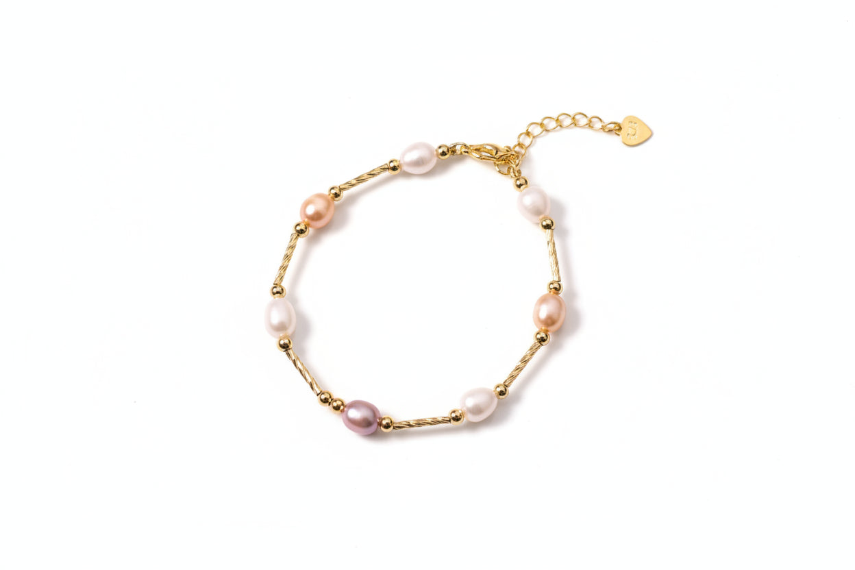 Gold bracelet with pearls on a beige background