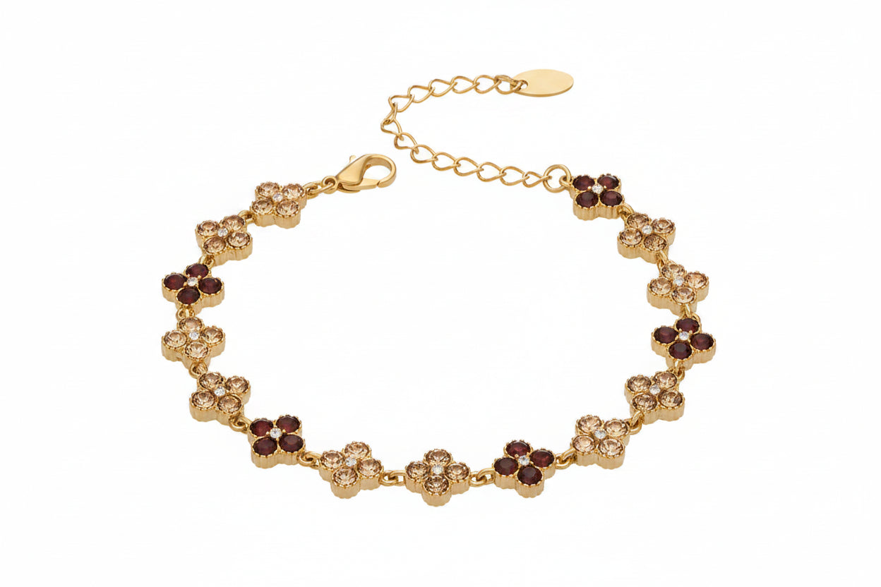 Gold bracelet with red stones and measurements on a white background
