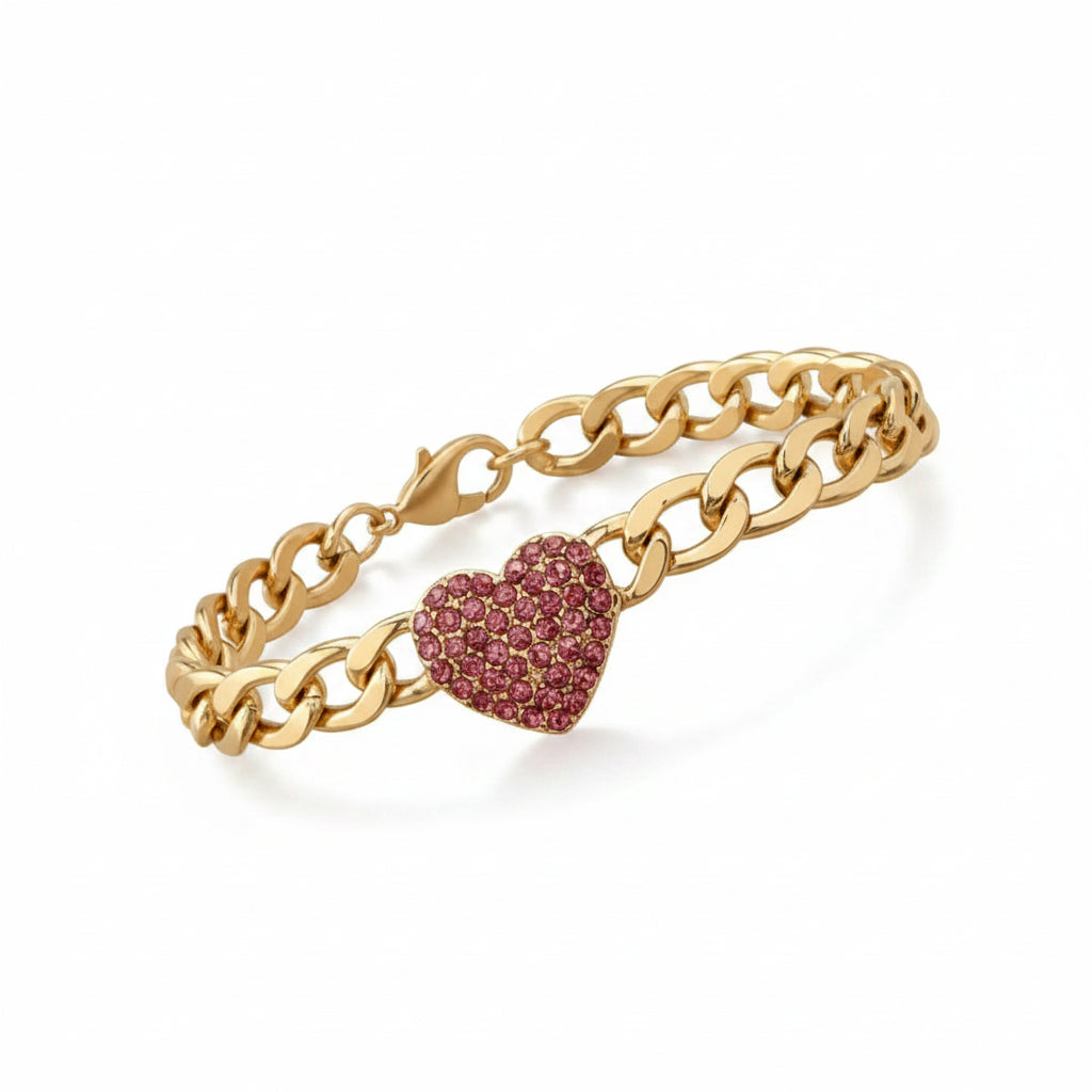 Gold chain bracelet with pink heart-shaped charm on a beige pillow