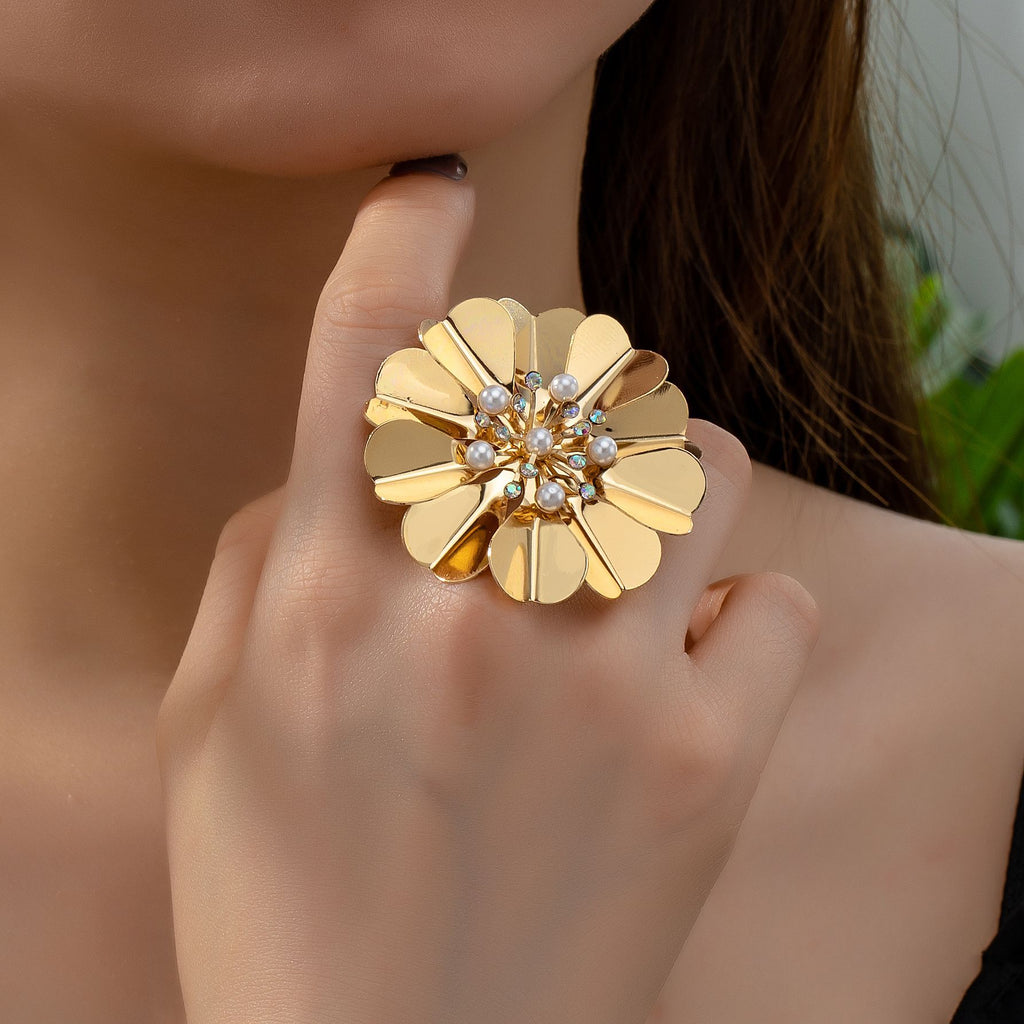 Gold flower-shaped ring with gemstones on a hand