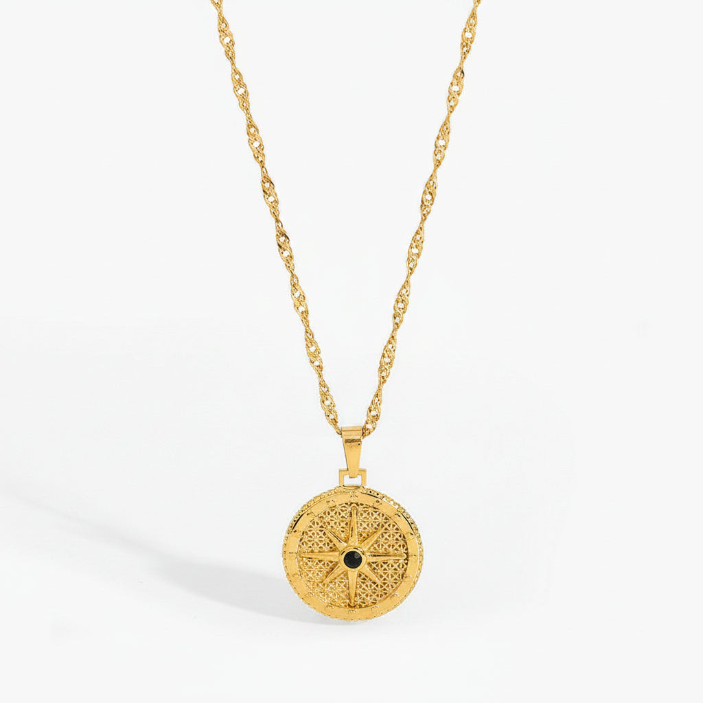 Gold necklace with a decorative pendant on a white background
