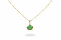 Gold necklace with a green pendant on a person wearing a brown top.