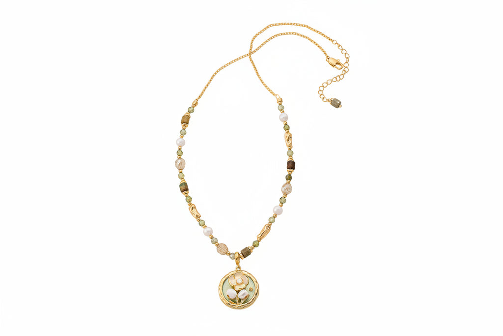 Gold necklace with a pendant on a textured surface