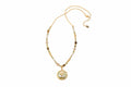 Gold necklace with a pendant on a textured surface