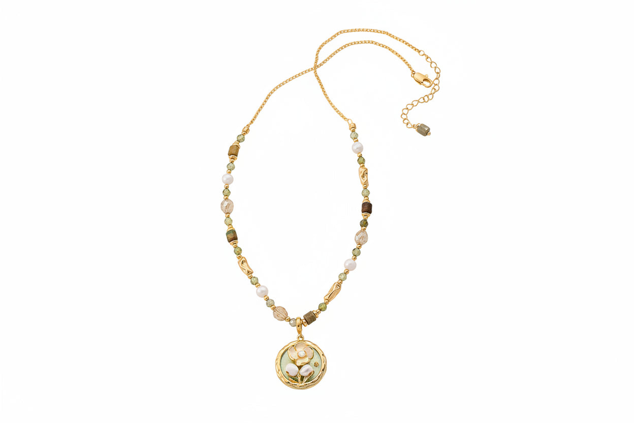 Gold necklace with a pendant on a textured surface