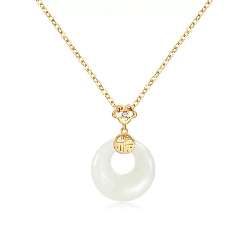 Gold necklace with a white pendant on a white background