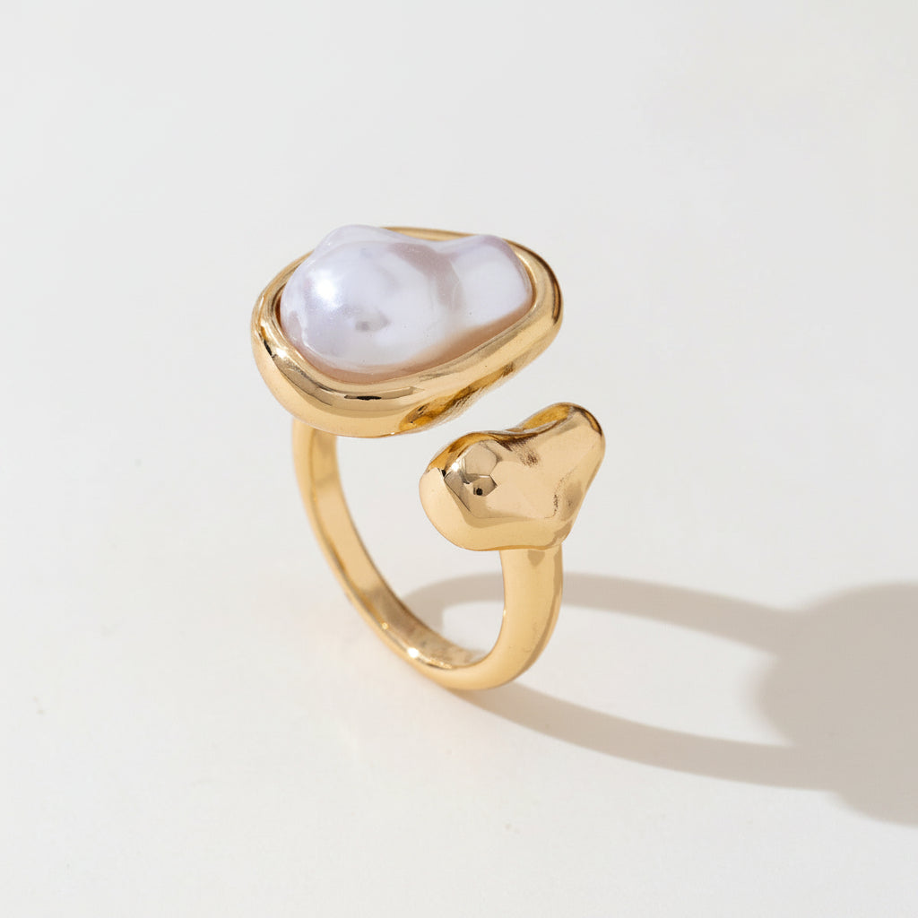 Gold ring with a white stone on a light background