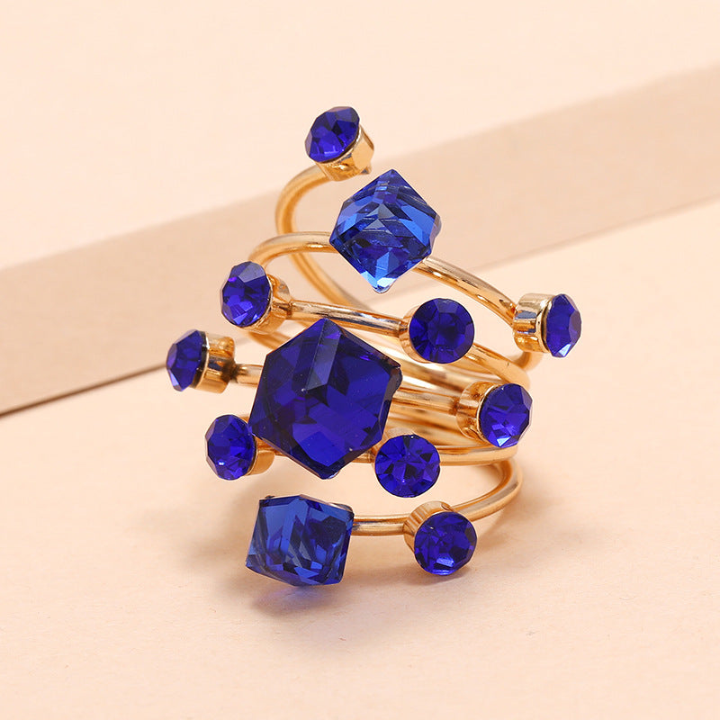 Gold ring with blue gemstones on a beige background