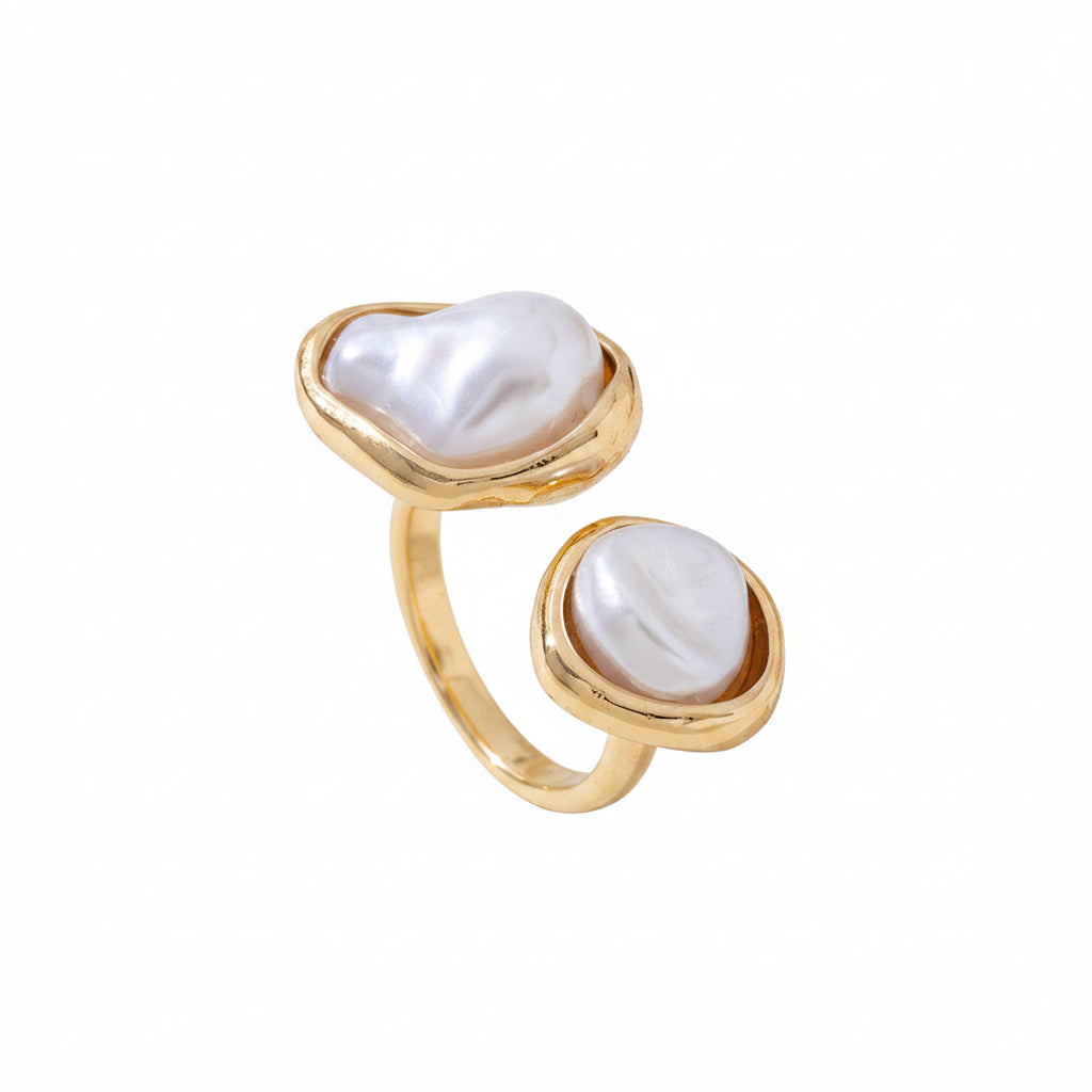 Gold ring with pearl stones on a light surface