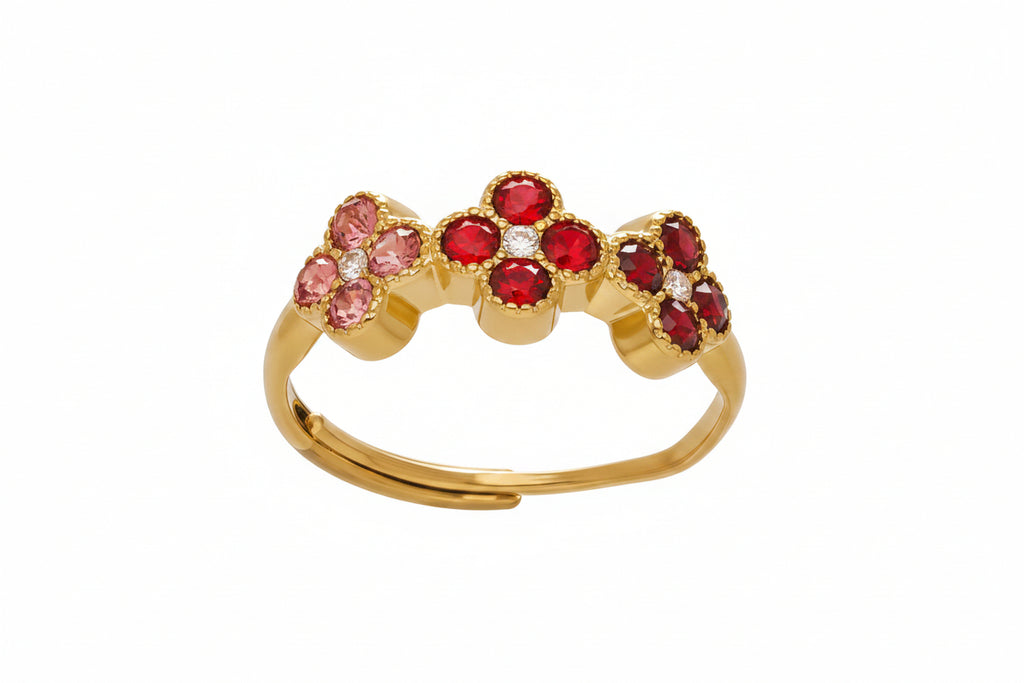 Gold ring with red and pink gemstones on a white background