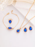Jewelry set with blue teardrop stones on a white surface