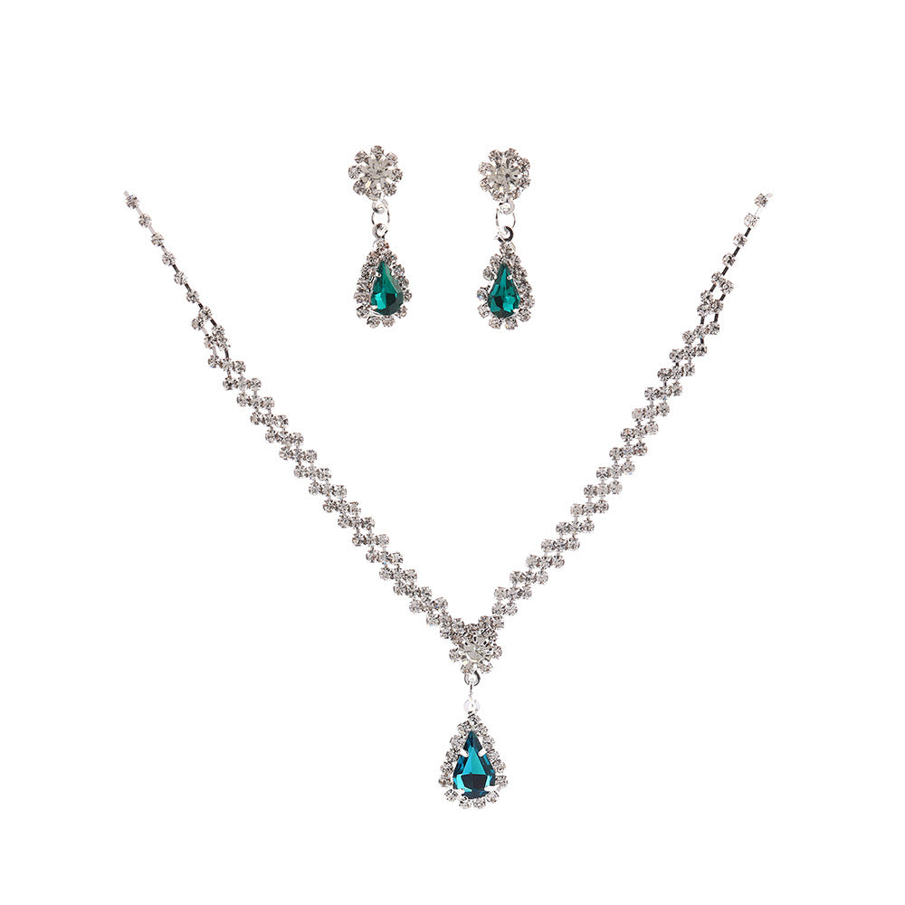 Jewelry set with necklace and earrings featuring teal teardrop stones on a white background