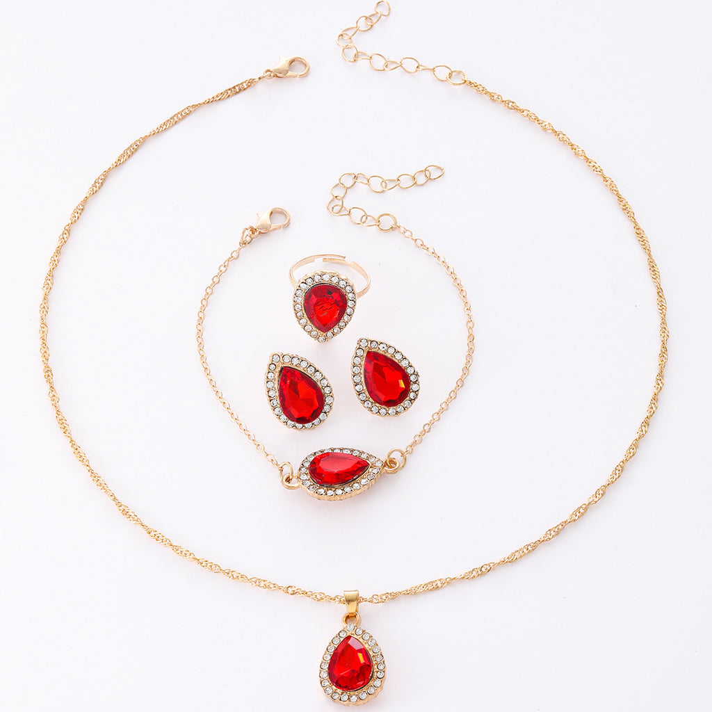 Jewelry set with red teardrop-shaped stones on a white background