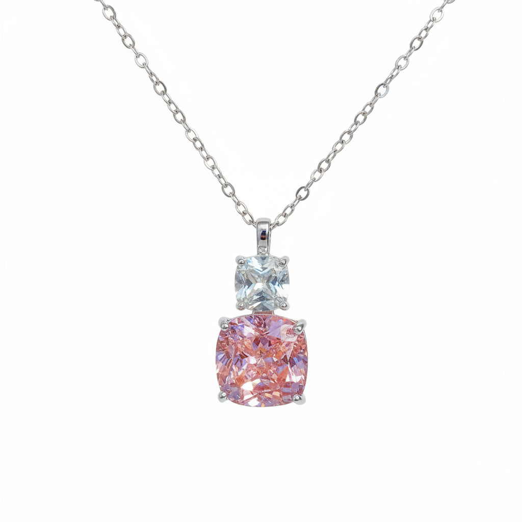Necklace with a pink and blue gemstone pendant held in a hand.