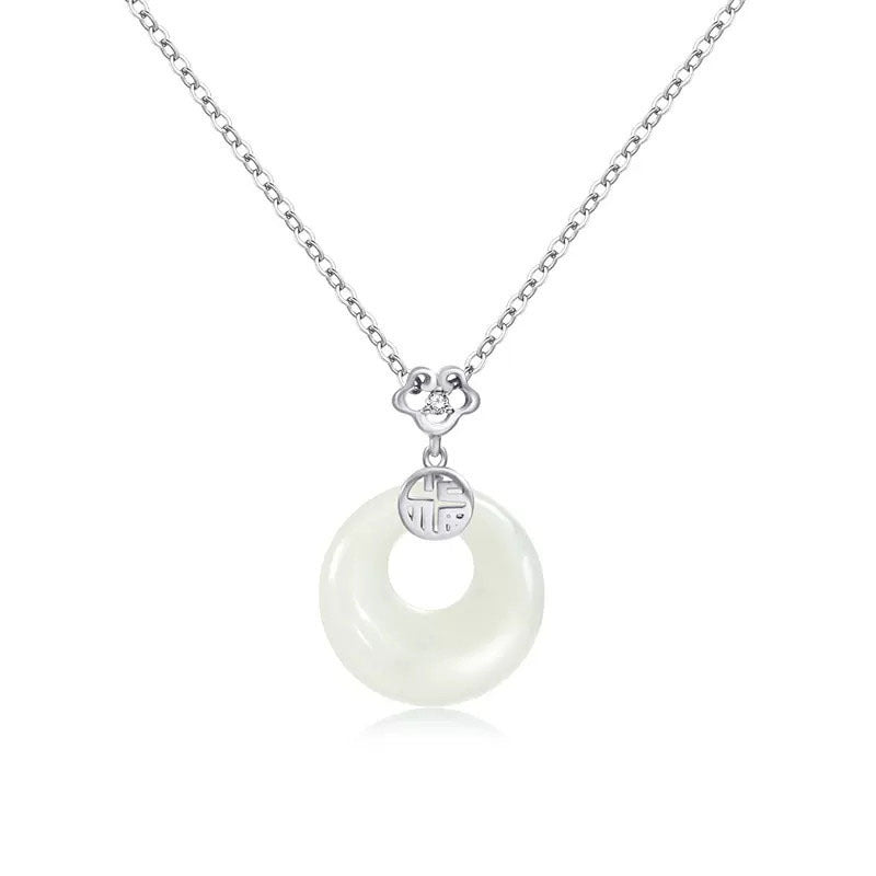 Necklace with a white circular pendant and silver chain on a white background