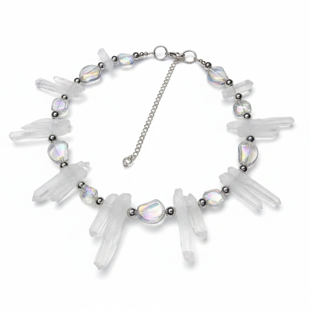 Necklace with clear crystal-like pendants on a reflective surface