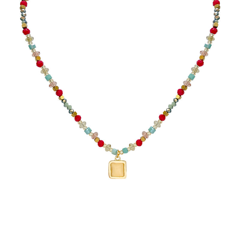 Necklace with multicolored beads and a gold pendant on a white background