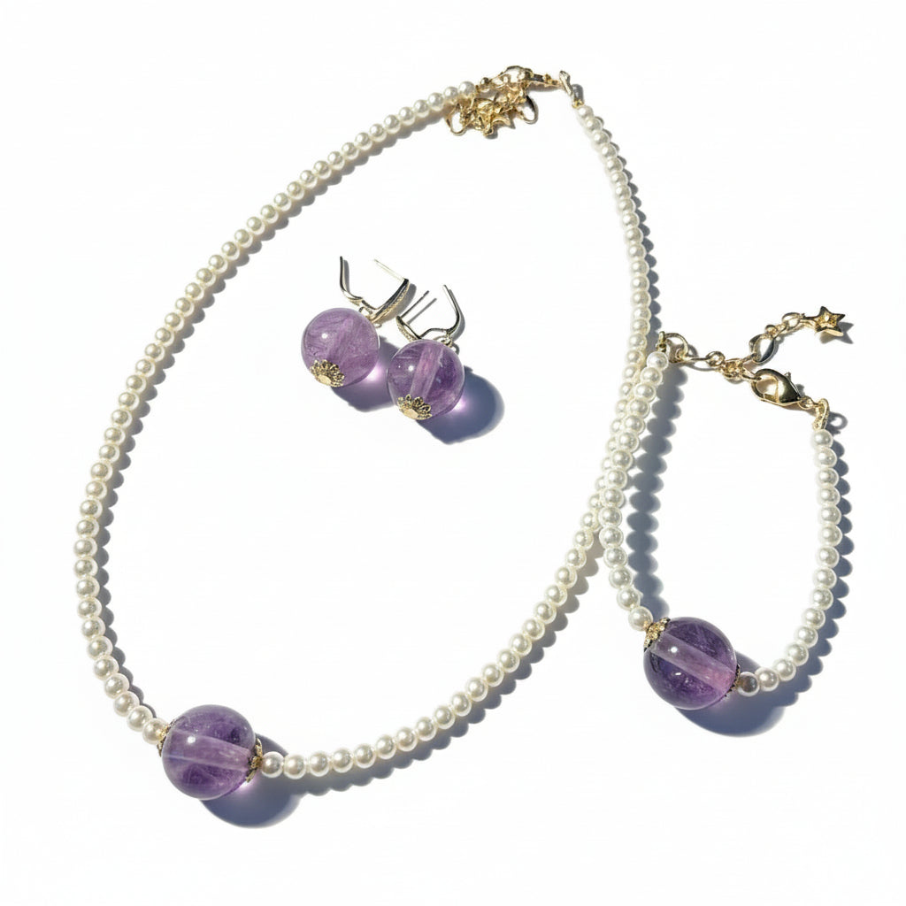 Necklace with purple beads and earrings on a dark floral-patterned surface