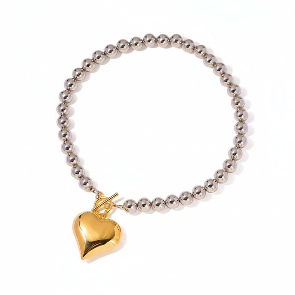 Silver beaded bracelet with a gold heart pendant, showing measurements on a white background.