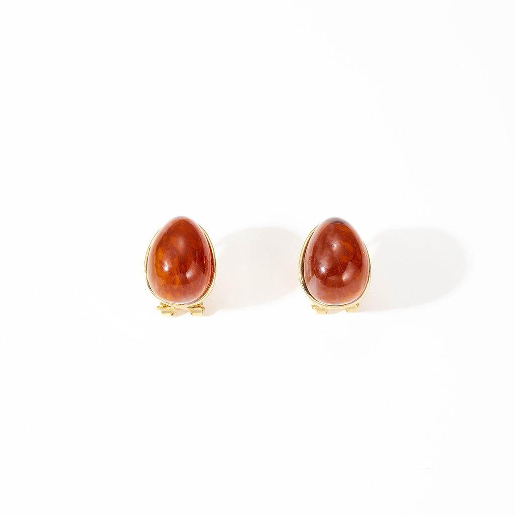 Pair of earrings with red stones on a white background