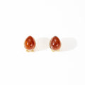 Pair of earrings with red stones on a white background