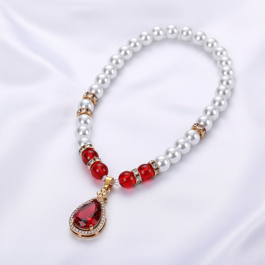 Pearl and red gemstone necklace in a red jewelry box on a white background