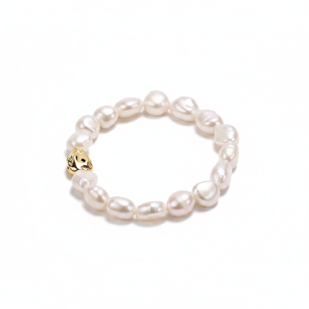 Pearl bracelet with a gold clasp on a beige background