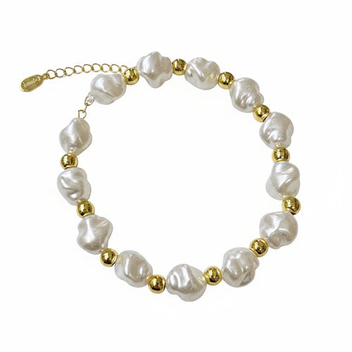 Pearl bracelet with gold beads on a white surface