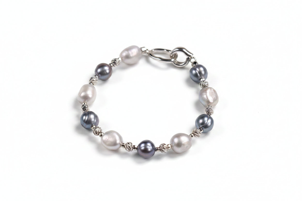 Pearl bracelet with silver accents on a beige background