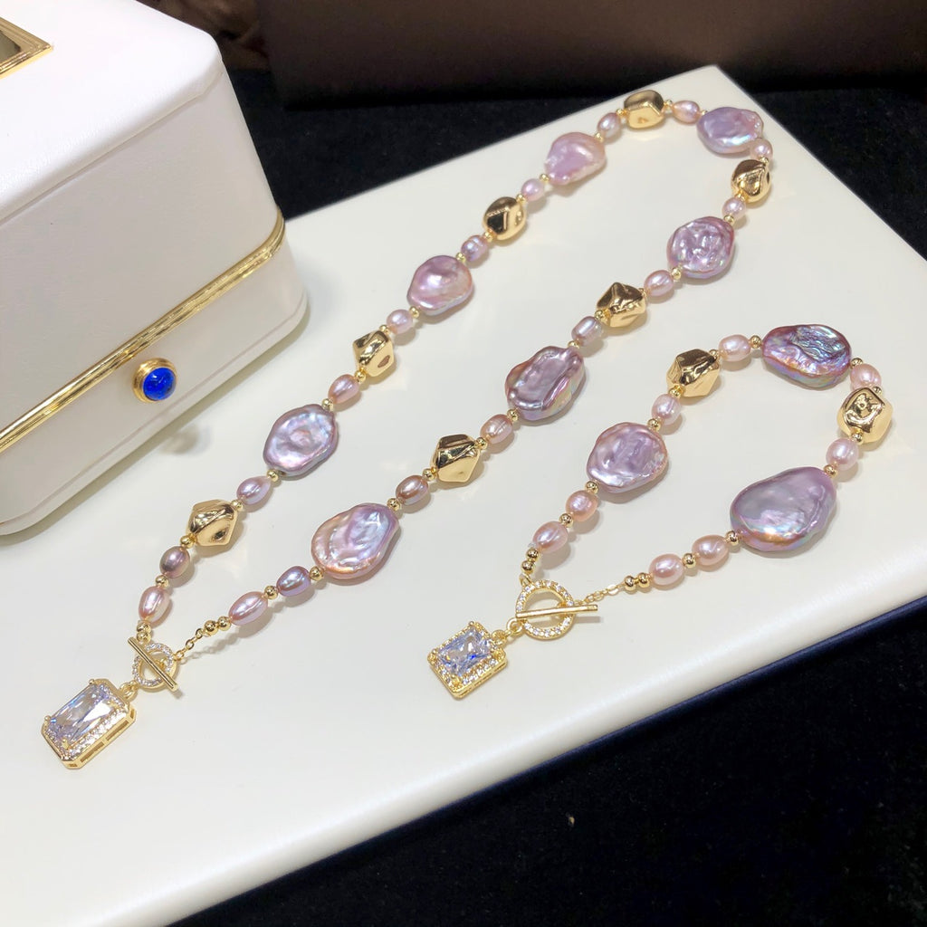 Pearl necklace with gold accents on a white surface