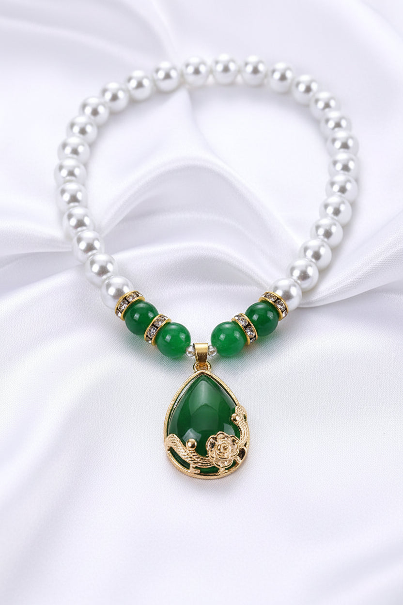 Pearl necklace with green jade pendant in a red box on a white background