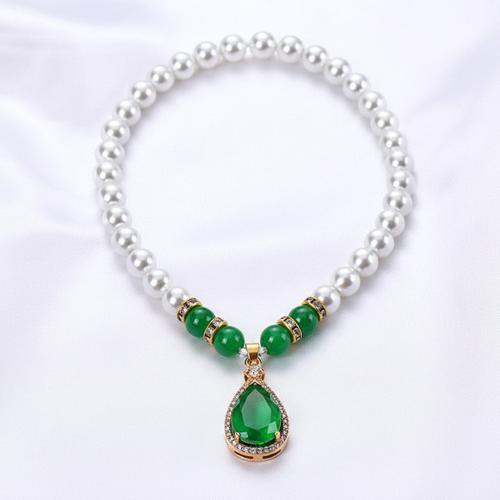 Pearl necklace with green pendant in a red box on a white background
