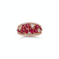Ring with red gemstones on a finger against a neutral background