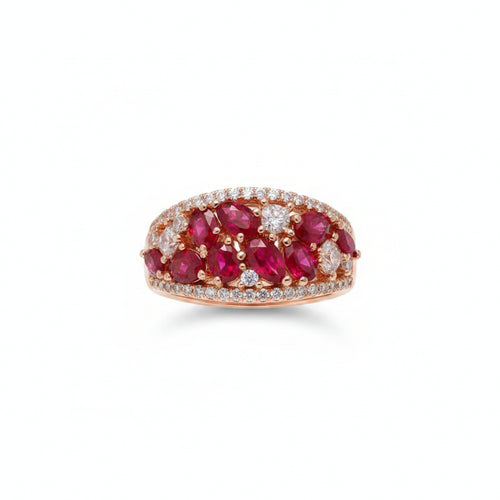 Ring with red gemstones on a finger against a neutral background