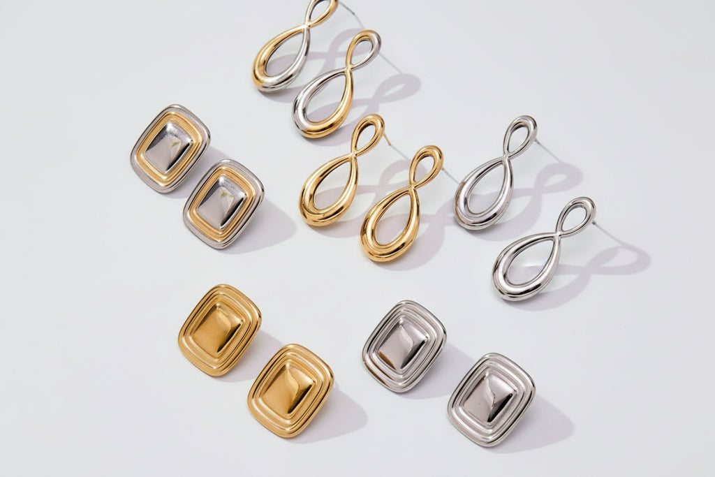 Set of gold and silver earrings on a light background