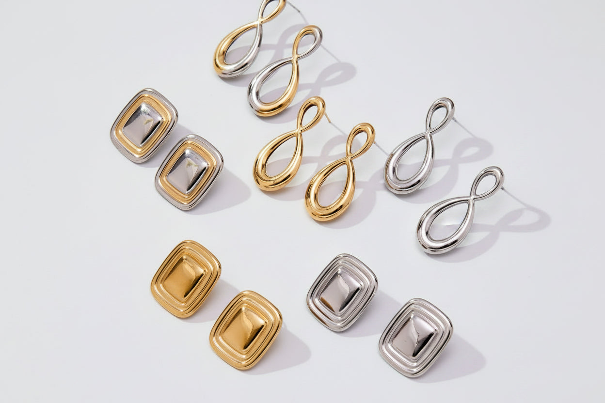 Set of gold and silver earrings on a light background