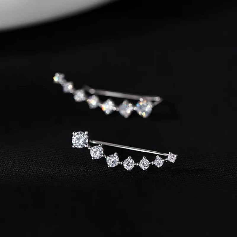 Silver earrings with clear gemstones on a black background